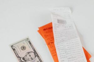 Inflación de julio 2026: billete de dólar junto a recibos de compras
