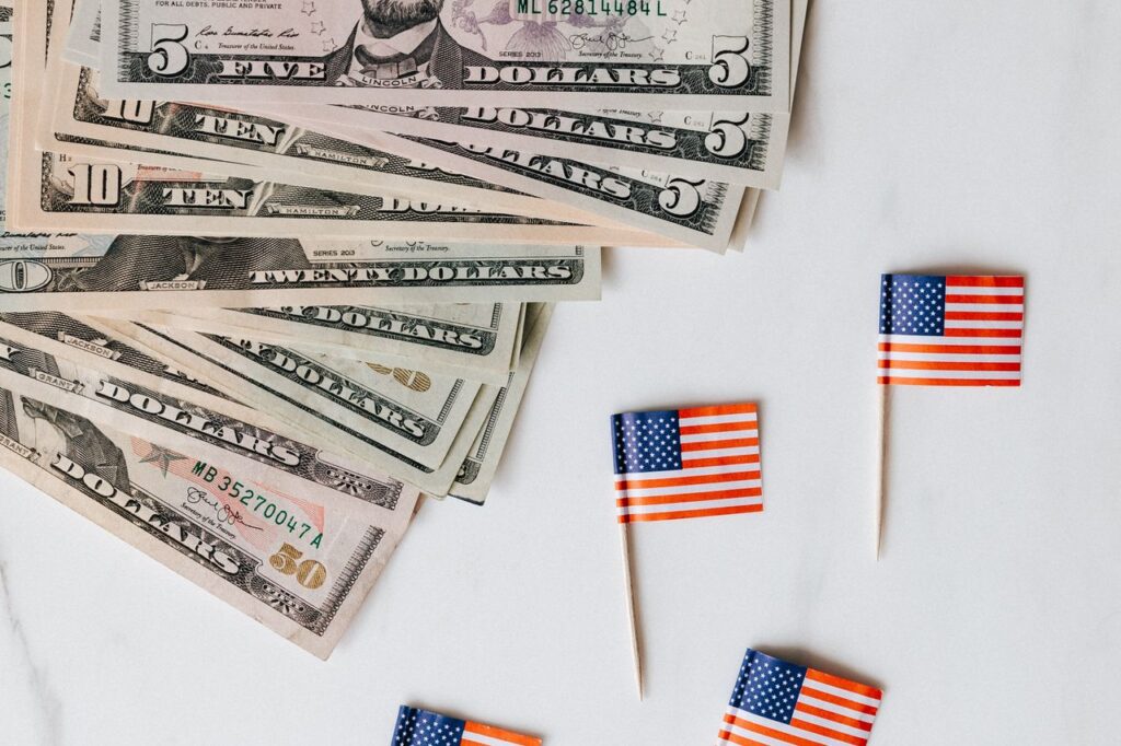 Billetes de dólar junto a banderas de Estados Unidos, representando el momento en que la deuda de EE.UU. llegó a $40 billones