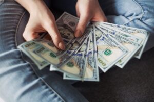 Abanico de billetes de 100 dólares, representando el dinero rápido que se puede ganar con trabajo físico