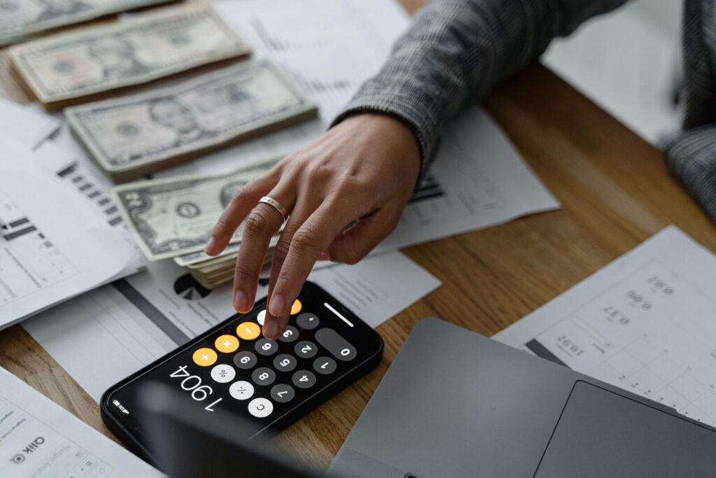 Cuenta de ahorro con 10% de interés: persona calculando sus ahorros con dólares y una calculadora