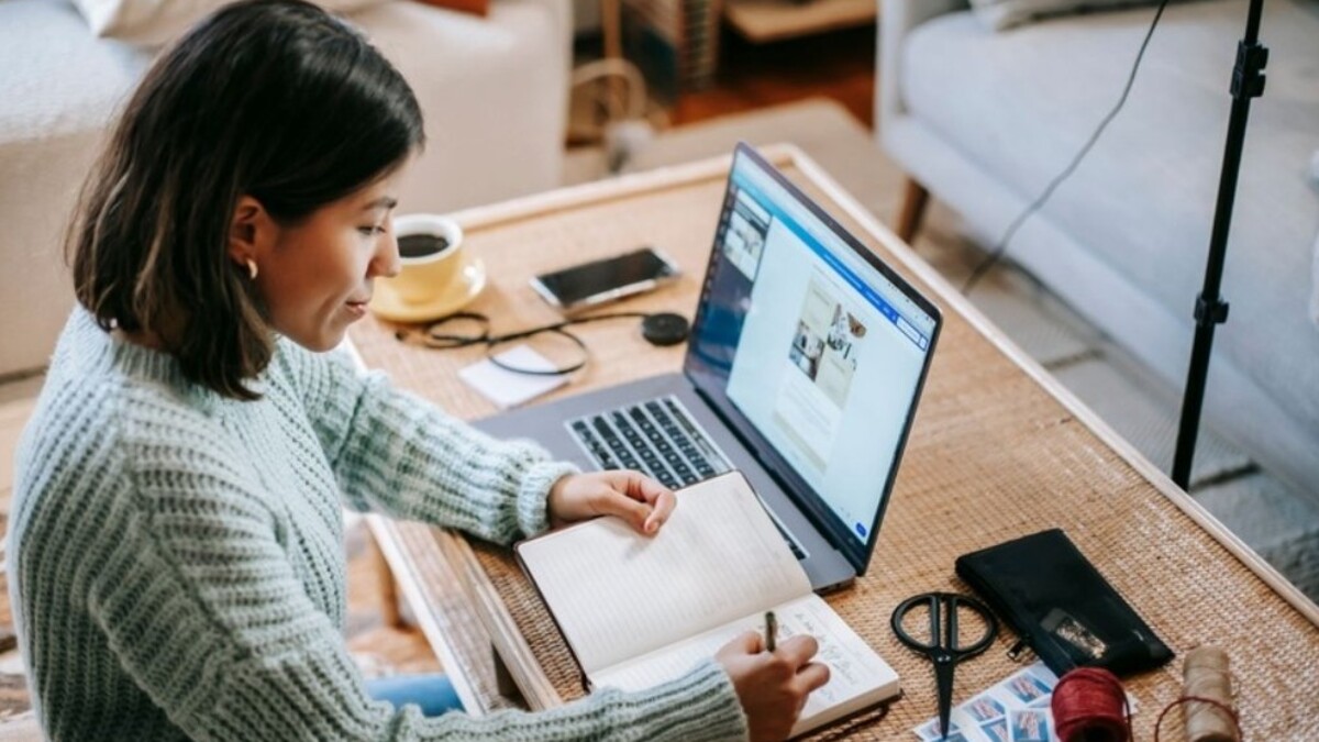 Cómo se calcula el puntaje de crédito: mujer revisando sus finanzas en casa con laptop y cuaderno