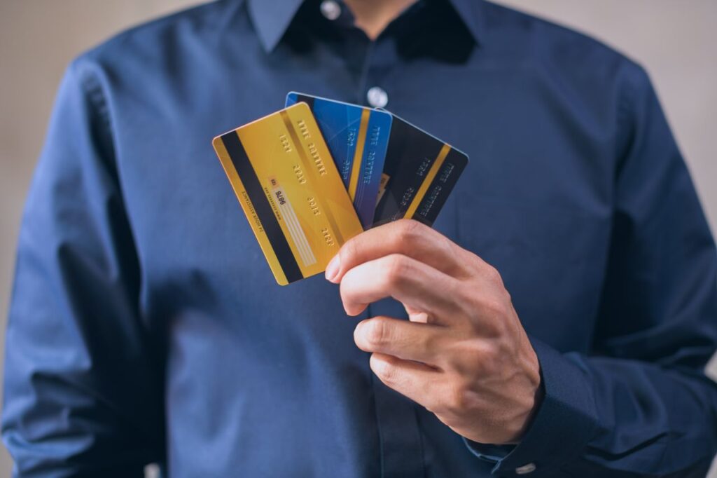reparar tu crédito, persona mostrando varias tarjetas de crédito