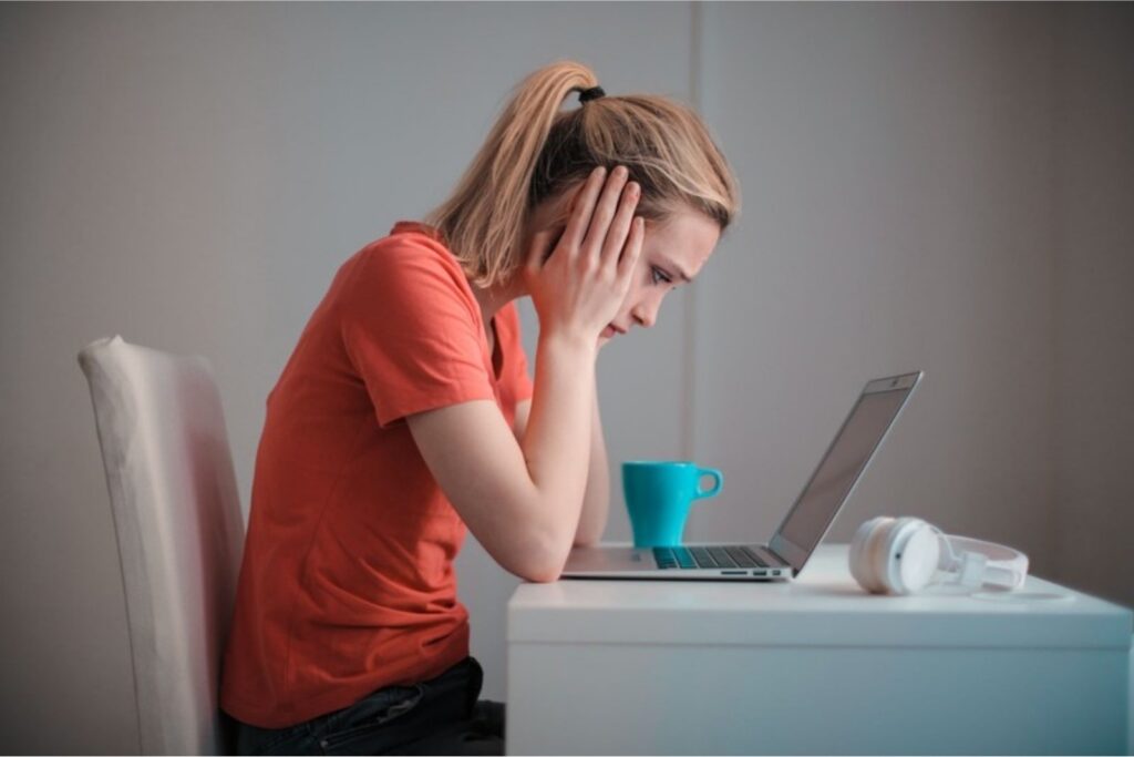 robo de identidad: mujer preocupada mirando su computadora portátil