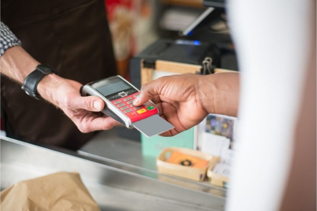 Persona pagando con su primera tarjeta de crédito en una tienda
