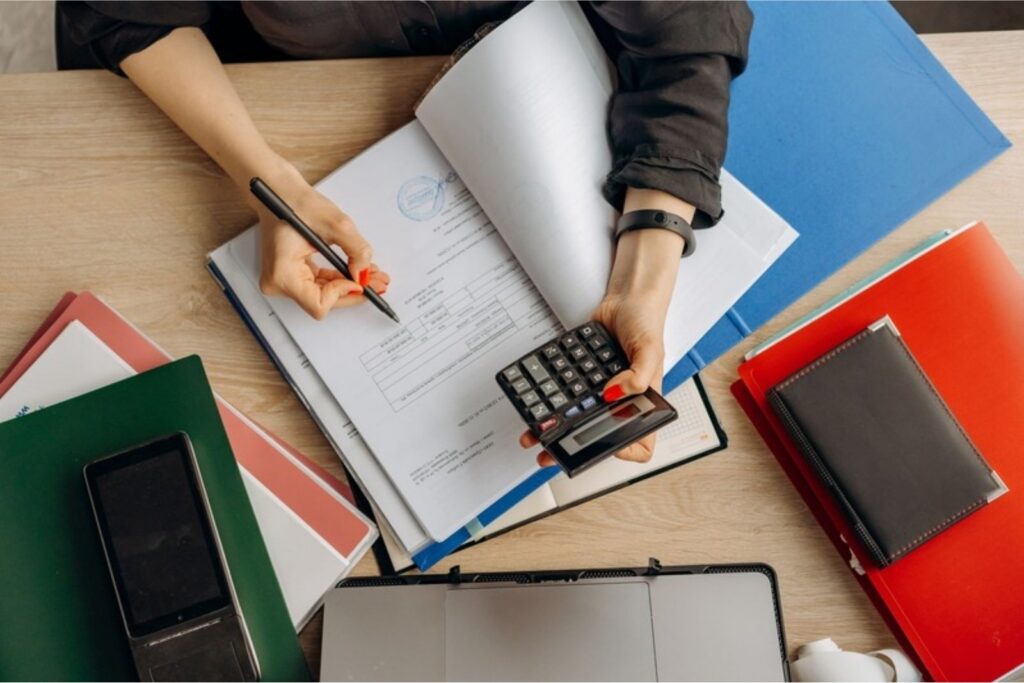 formulario W-2: persona revisando papeles de impuestos con una calculadora