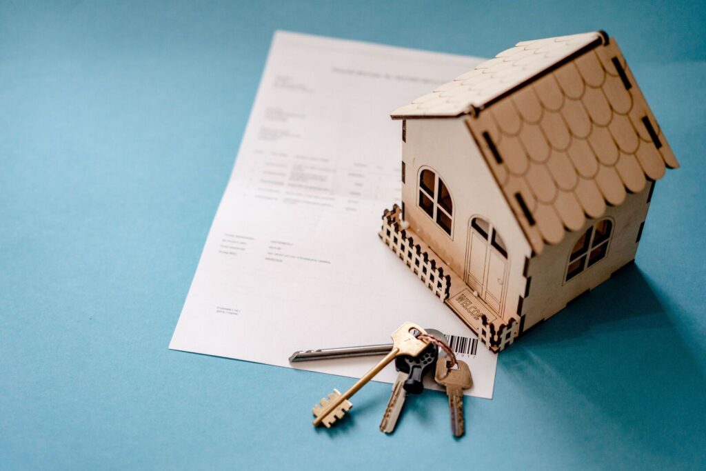 Tasas hipotecarias casi al 7 por ciento: casa en miniatura con llaves y contrato