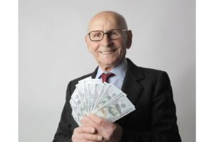 Persona mayor con billetes de dólar por herencia de IRA