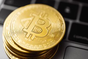Monedas de Bitcoin sobre un teclado, el precio de Bitcoin sube a 86000 dolares