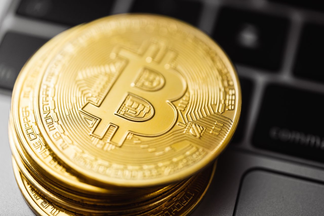 Monedas de Bitcoin sobre un teclado, el precio de Bitcoin sube a 86000 dolares