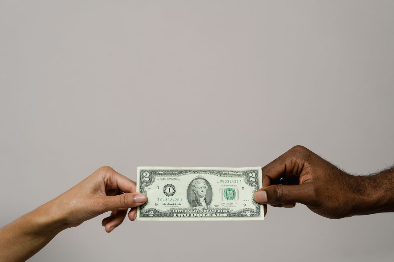 Billete pasando de una mano a otra, enviar dinero a Latinoamérica