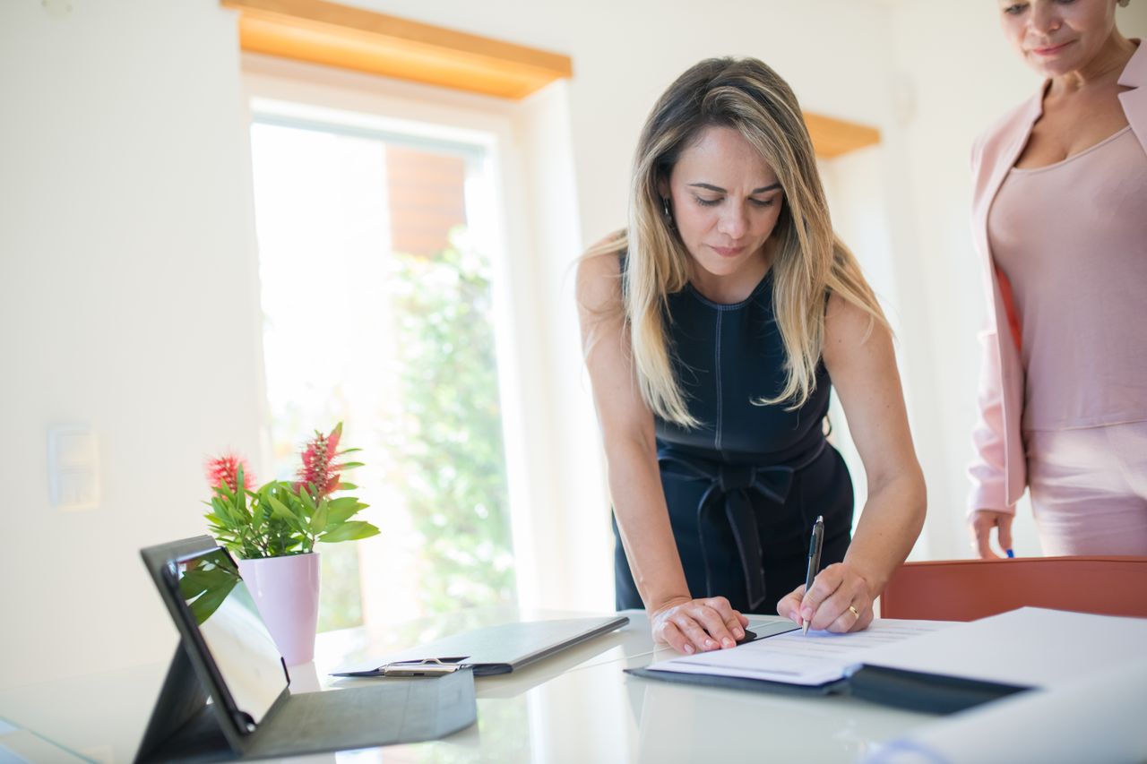 Mujer firmando los documentos de registro para abrir una LLC