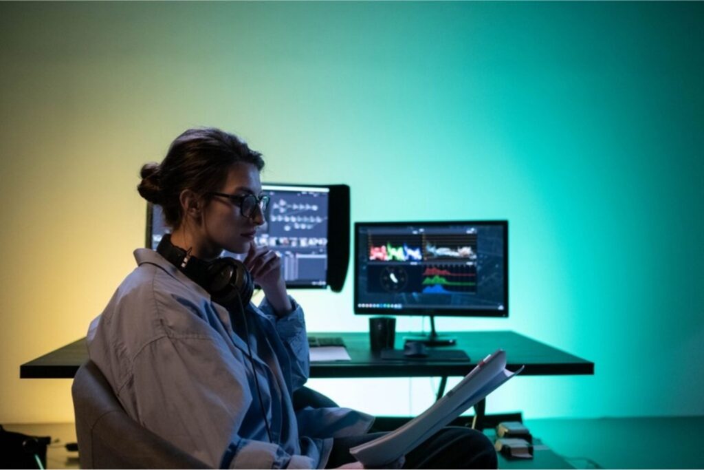 Persona trabajando con dos monitores en un escritorio moderno, sobre los trabajos para bilingües