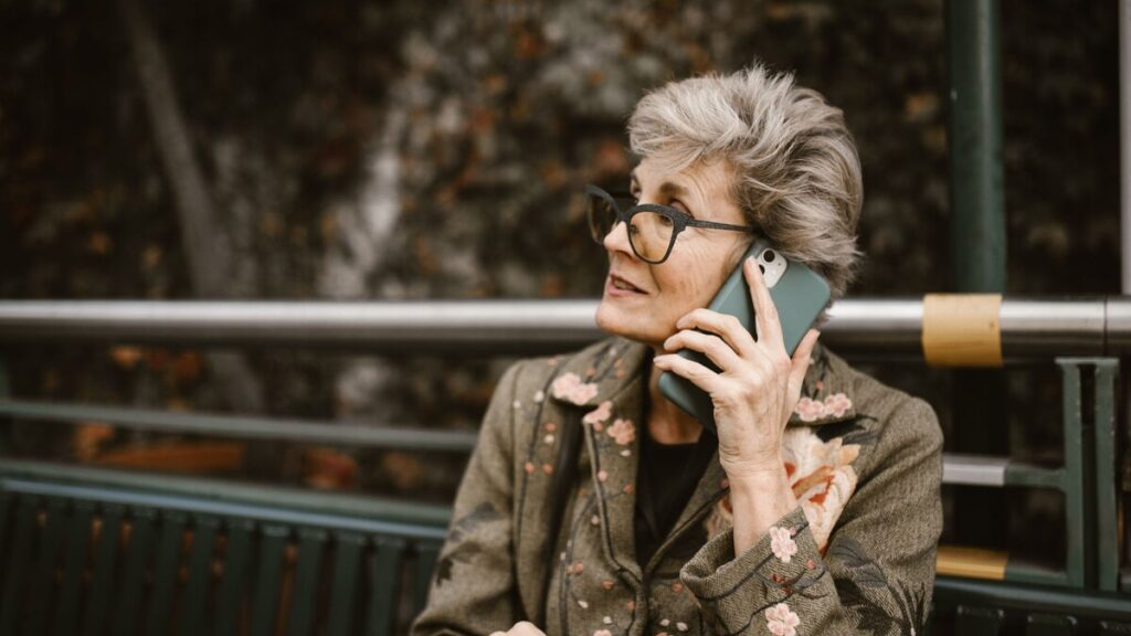 Estafa del nieto: mujer mayor preocupada hablando por teléfono en casa