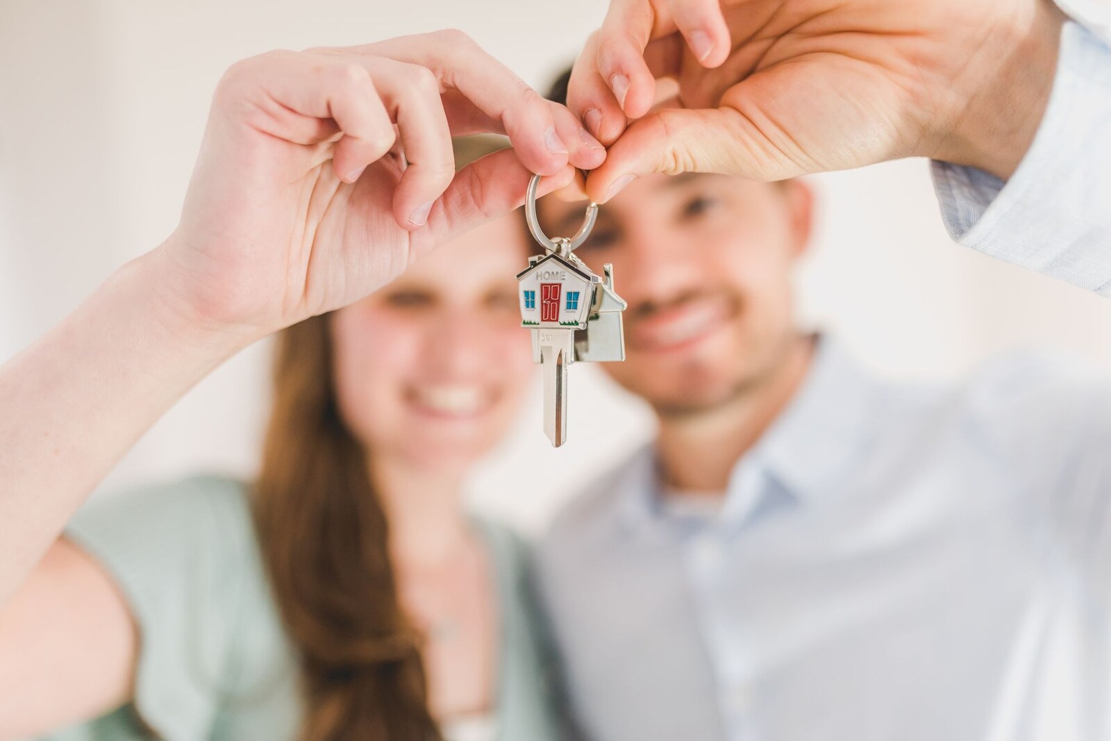 Hipoteca: pareja sonriendo con la llave de su casa