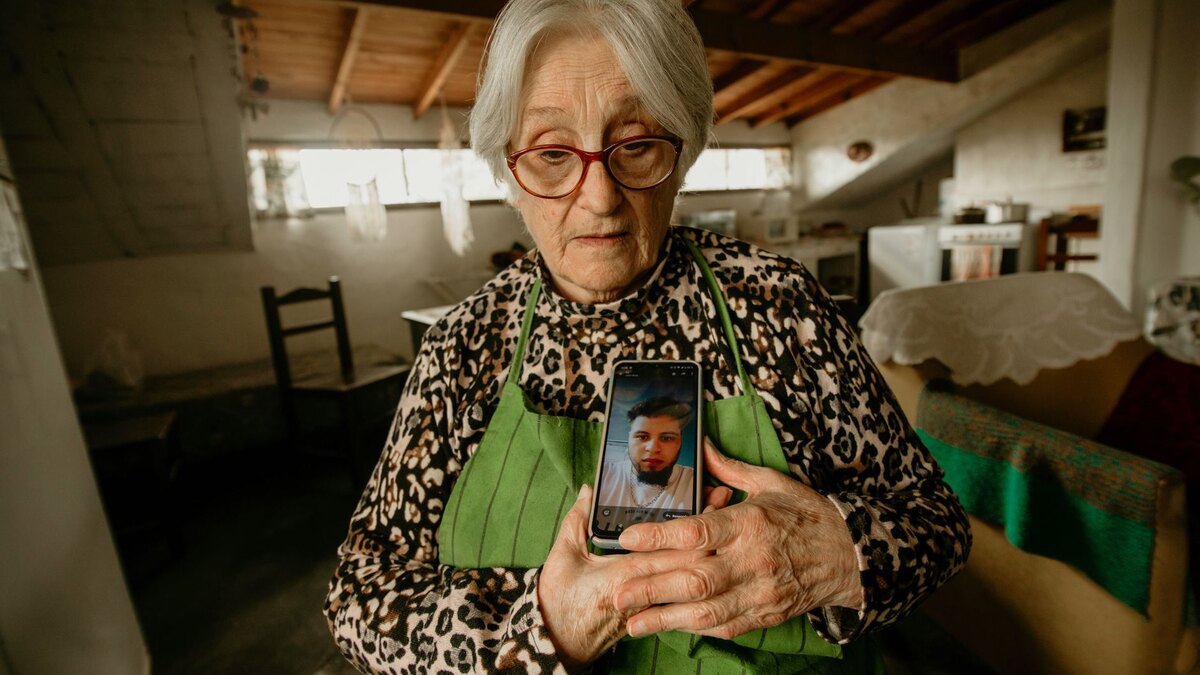 Mujer mayor mostrando en su teléfono la foto de un familiar