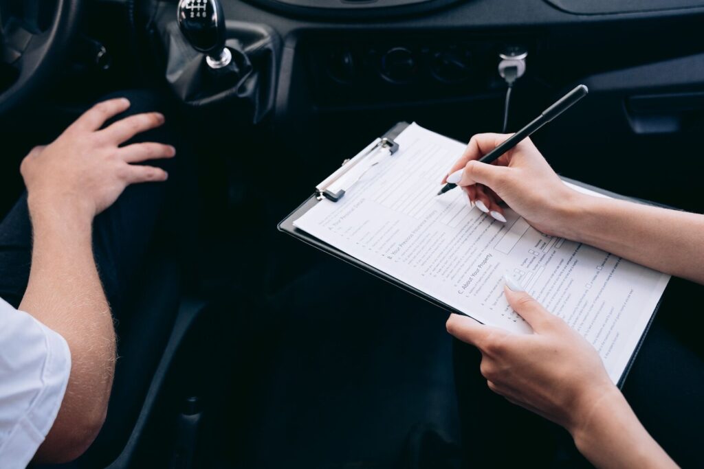 Seguro de carro: agente con una planilla dentro de un auto