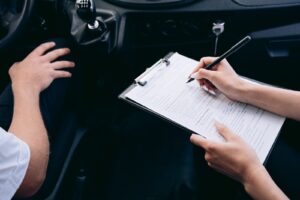 Seguro de carro: agente con una planilla dentro de un auto