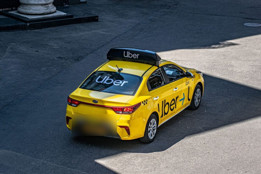 Conductores latinos de Uber: taxi amarillo con el logo de Uber en el techo, el vidrio trasero y la puerta
